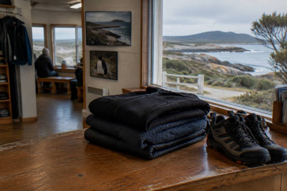 A folded pile of dark warm clothing and enclosed walking shoes ready for an evening wildlife tour